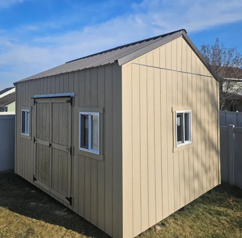 Beige storage shed with windows and door.