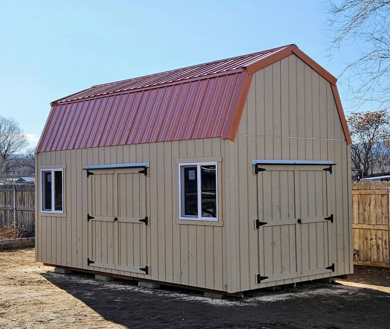 Wooden shed with red metal roof.